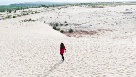 aerial view of a girl walking in the desert in vietnam.