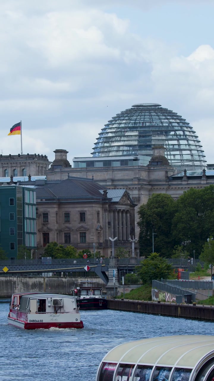 Barcos navegando por el río Spree pasando el edificio del Reichstag en Berlín