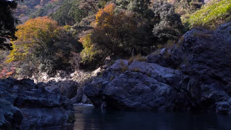 Ruhiger-Blick-Auf-Große-Steinblöcke-Und-Herbstfarben-Mit-Fließendem-Fluss