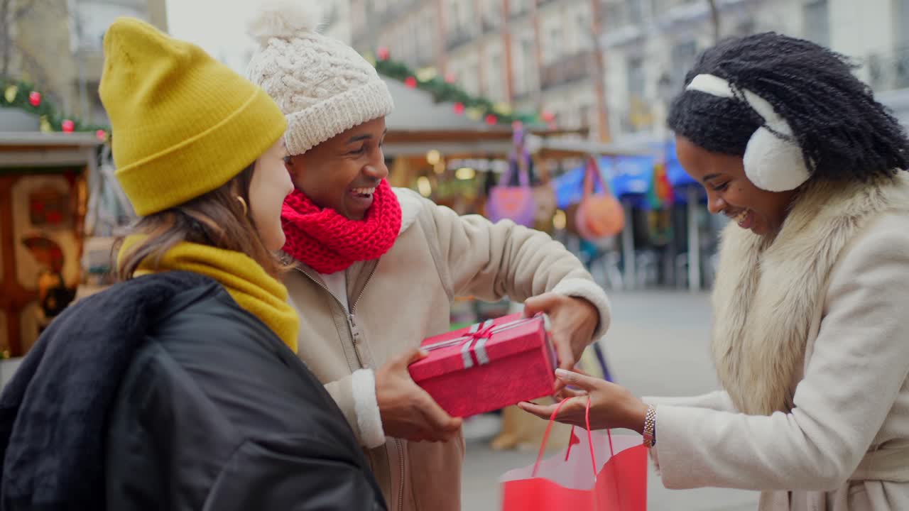 Friends Exchanging Gifts at a Christmas Market