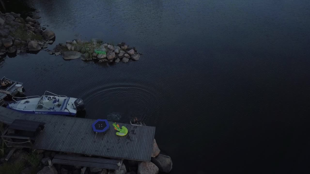 AERIAL young boy on jetty jumping in the water alone, dangerous swimming without adult supervision