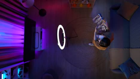 man recording video in his living room using a ring light