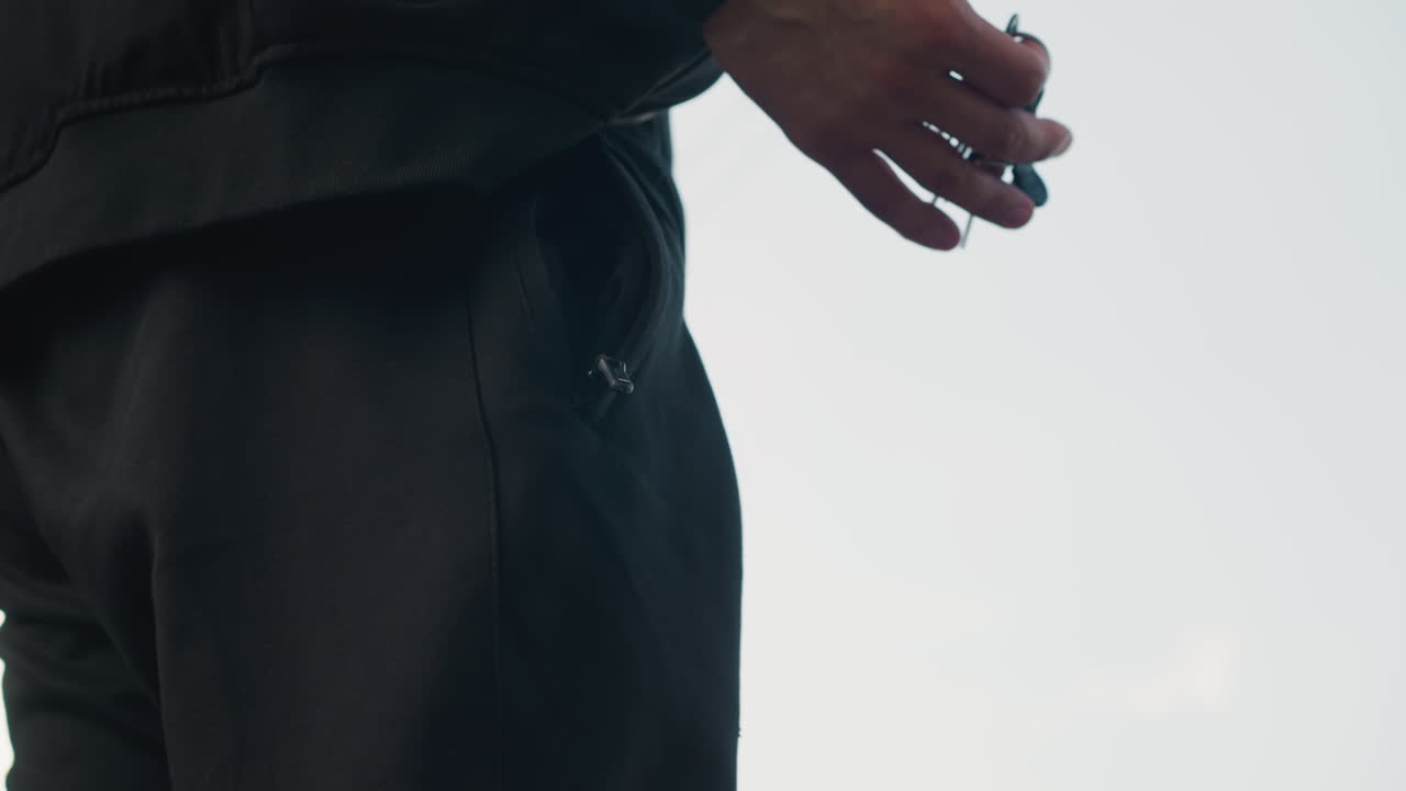 고요한 도시 풍경을 거니는 어두운 형체, 평화로운 도시의 황혼 속에서 그림자가 드리워진 개인의 옆모습, 도시 환경의 고요한 황혼 동안 열쇠를 들고 있는 사람의 사색적인 실루엣