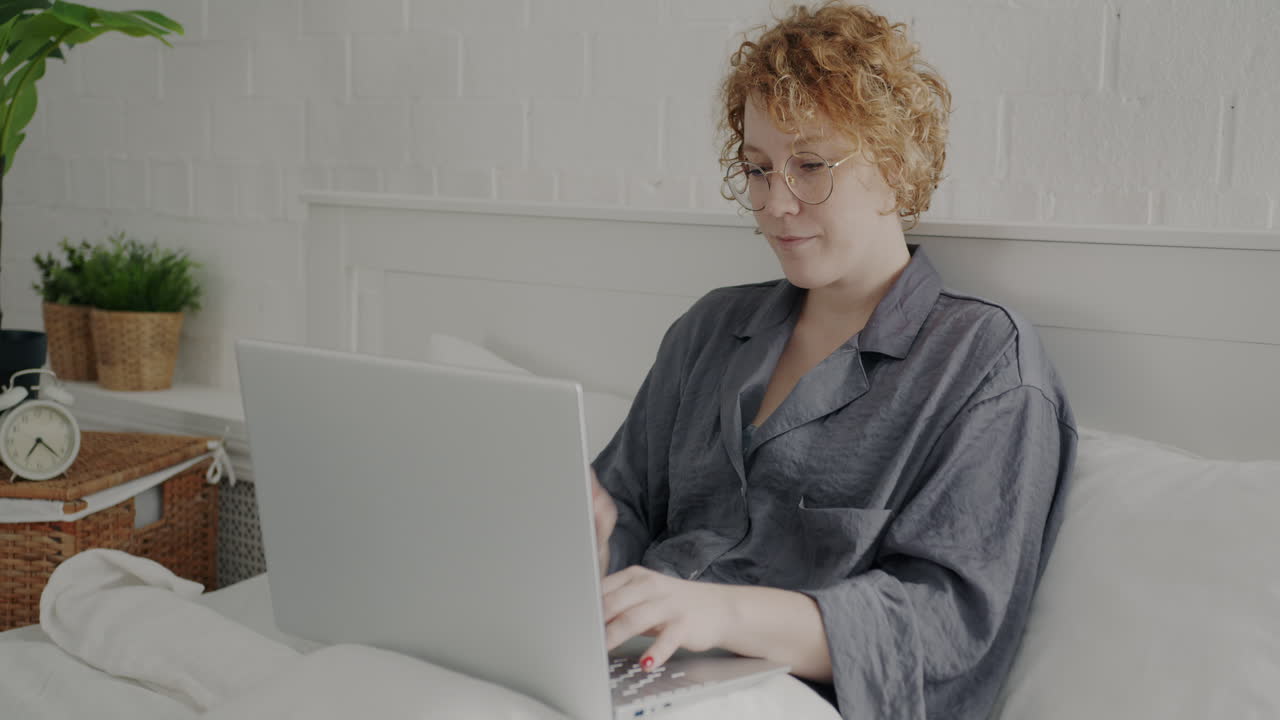 mujer trabajando en la computadora portátil en la cama