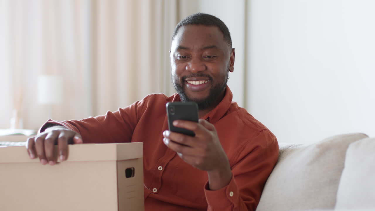 Man Using Smartphone on Sofa During Move