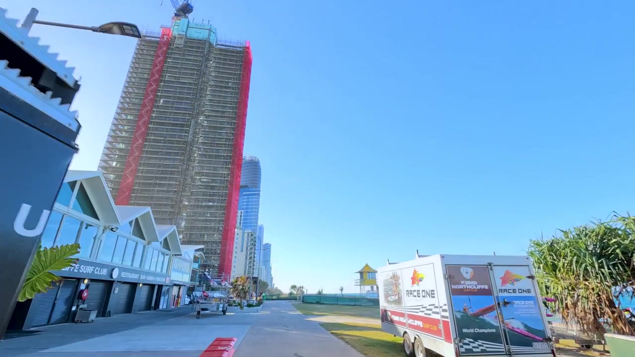 Ripresa in movimento attraverso un ponteggio metallico arrugginito da costruzione sopra un marciapiede a Broadbeach, Australia
