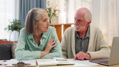 Elderly couple reviewing finances at home