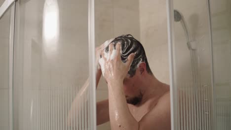 hombre lavándose el cabello en la ducha