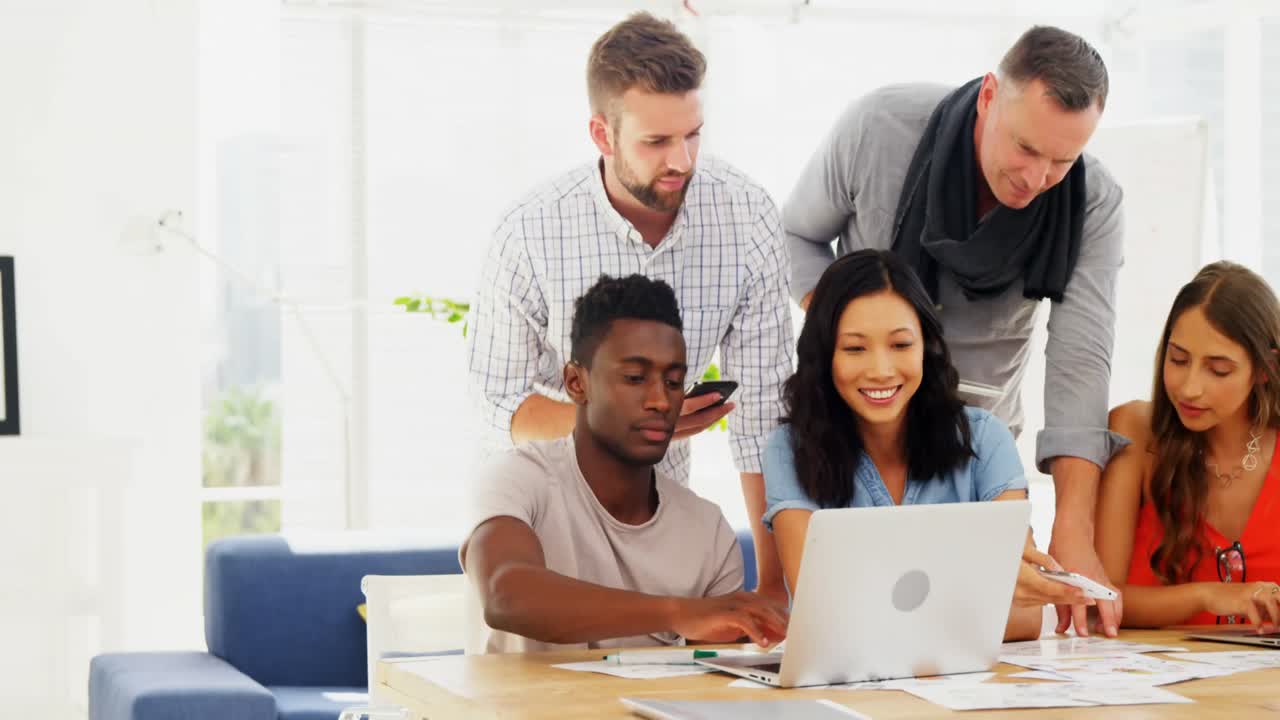Team of executives interacting with each other while working in the office
