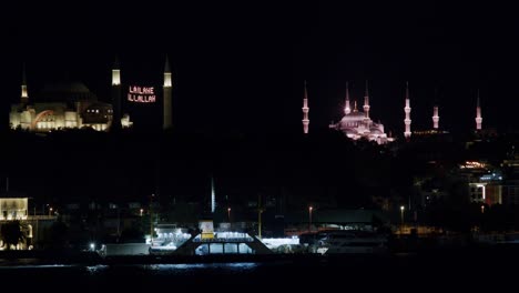 passenger boat crossing the shore at night, mosques with la ilahe illallah written, istanbul, turkey