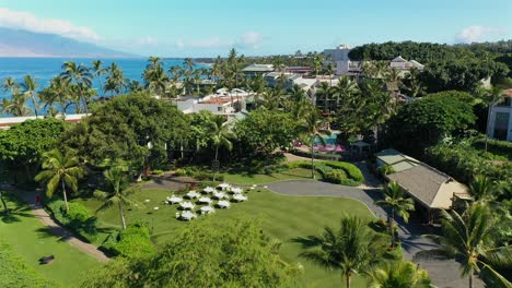 low aerial approach over a large open grassy area with tables