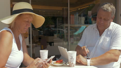 Una-Pareja-En-Una-Cafetería-Ocupada-Con-Sus-Dispositivos.