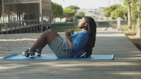 long shot of fat american woman doing abdominal crunches outdoor