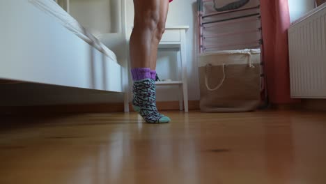 las piernas de la mujer en el dormitorio con calcetines de patrones coloridos