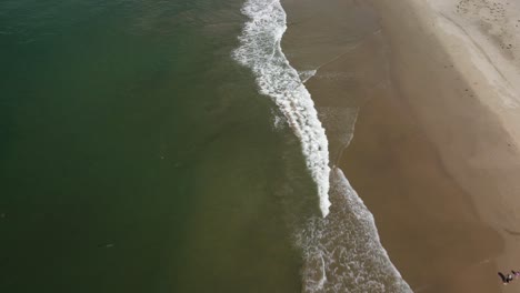 Die-Drohne-Zieht-Sich-Zurück,-Während-Sie-Die-Kamera-Nach-Oben-Neigt-Und-Den-Strand-Freigibt