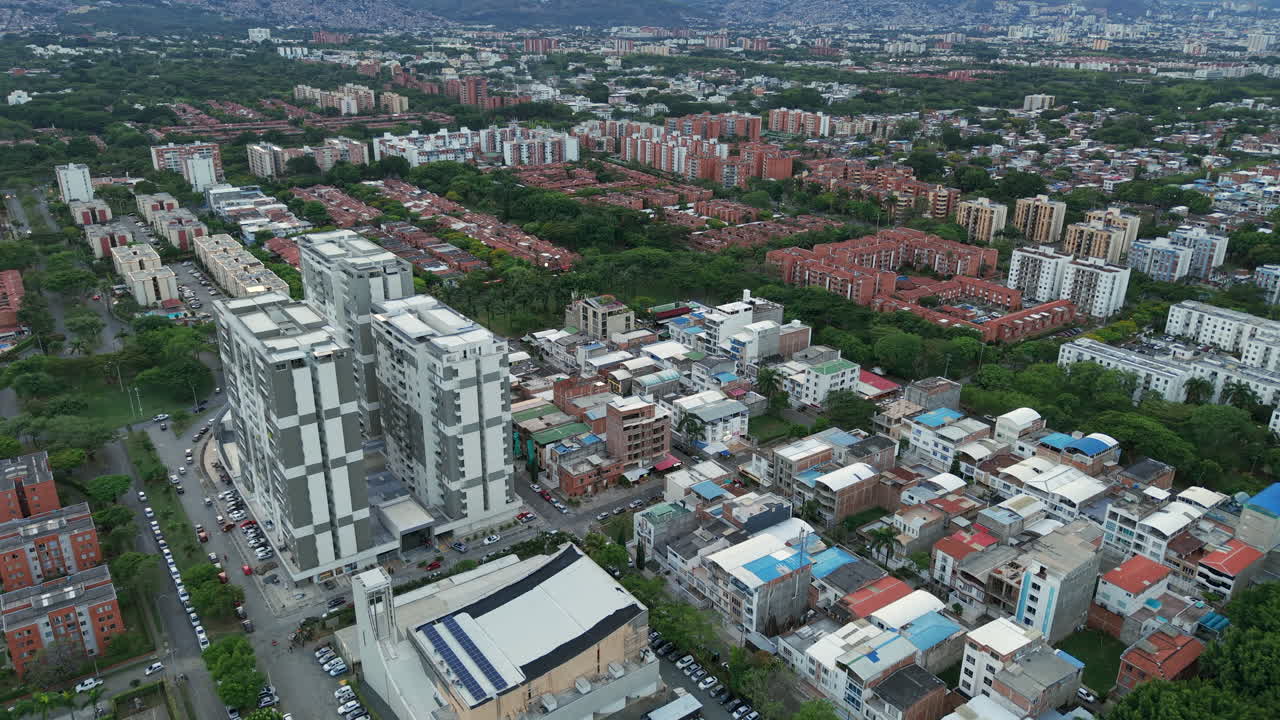 Stunning aerial footage captures the modern urban sprawl of Valle del Lili, showcasing vibrant architecture under diffuse lighting, with sweeping views of Cali's expansive horizon