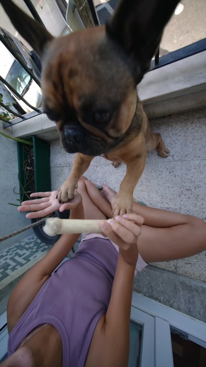 A person and a dog sharing a snack