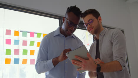 Front-view-of-young-mixed-race-business-team-working-on-digital-tablet-in-a-modern-office-4k