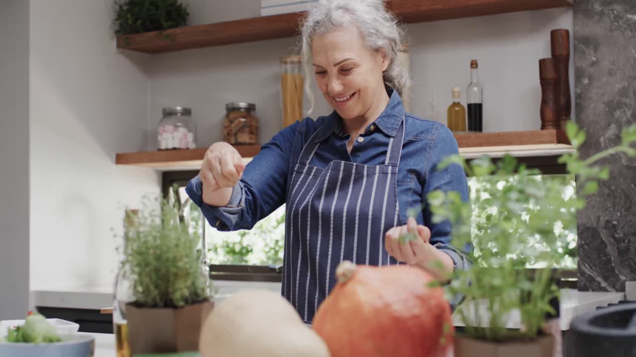 미소 짓는 고위 백인 여성이 부 ⁇ 에서 채소를 향신료로 만들고, 느린 동작