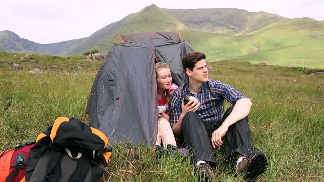 그 들 의 텐트 에서 수프 를 마시며 대화 하는 부부