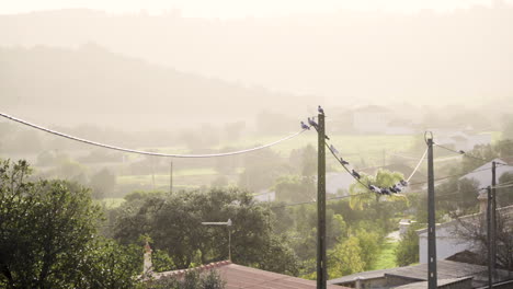 Los-Pájaros-Se-Posan-En-Un-Cable-Eléctrico-Alto-Con-Un-Paisaje-Al-Atardecer-De-Fondo