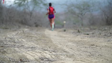 atleta de maratón corre muy rápido en un camino de tierra a través de la naturaleza rural de ecuador hacia la línea de meta tratando de ponerse al día con el trabajo pesado en cámara lenta 25 fps