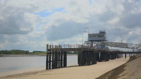 Verfallene-Docks-Mit-Schnellen-Grauen-Und-Weißen-Wolken-Mit-Schatten,-Die-Sich-über-Das-Bild-Bewegen,-Zeitraffer-30x