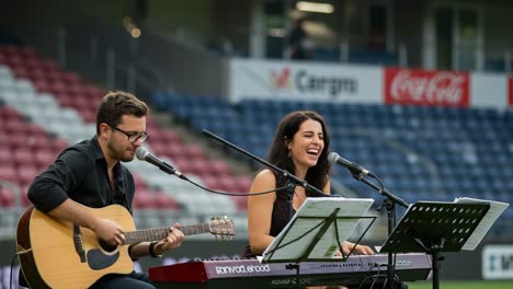 An Enchanting Musical Performance: A Duo Captivating the Audience with Acoustic Melodies and Joyful Harmonies at an Intimate Venue