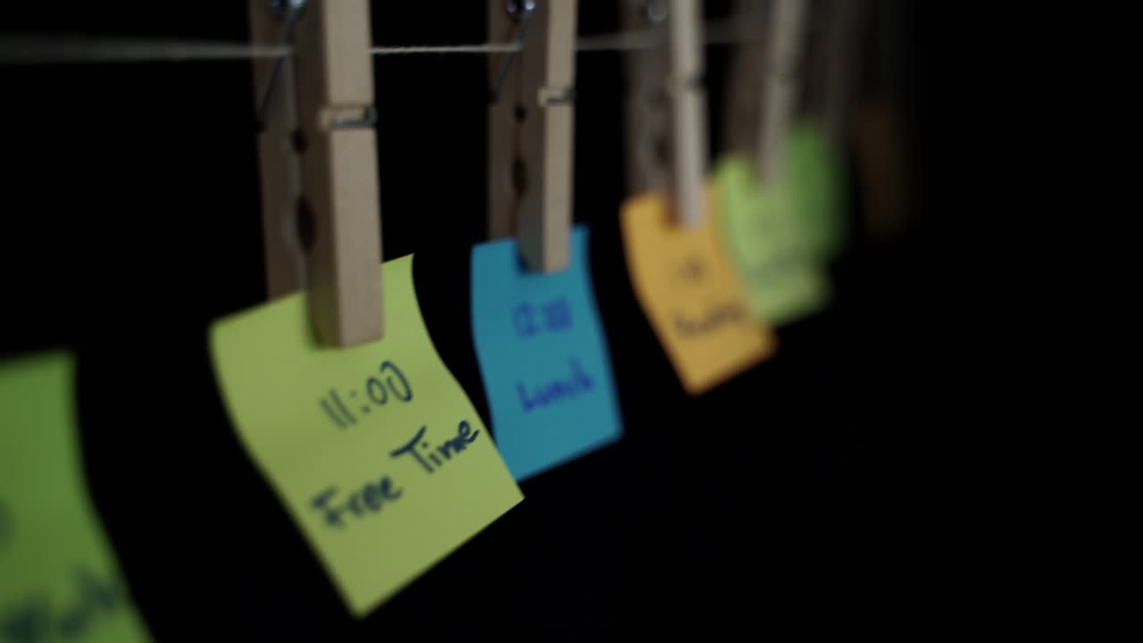 Schedule of student daily activities written on colorful note stickers in black background
