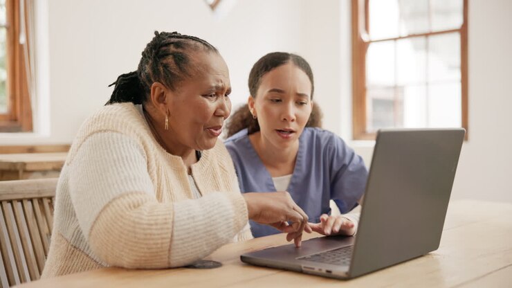 Donna anziana, casa e infermiera con un laptop
