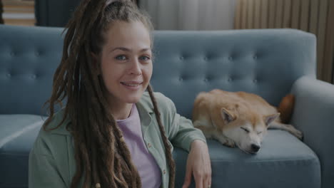 woman with dreadlocks and her shiba inu dog on a couch