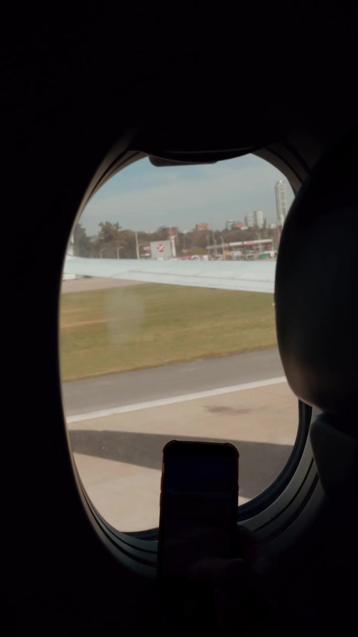 Passenger Filming Airport View From Airplane Window