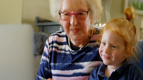 Grandmother-and-granddaughter-using-digital-tablet-in-living-room-4k