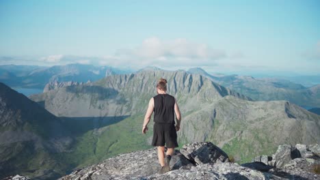 excursionista caucásico en el pico de la montaña en lonketinden, noruega