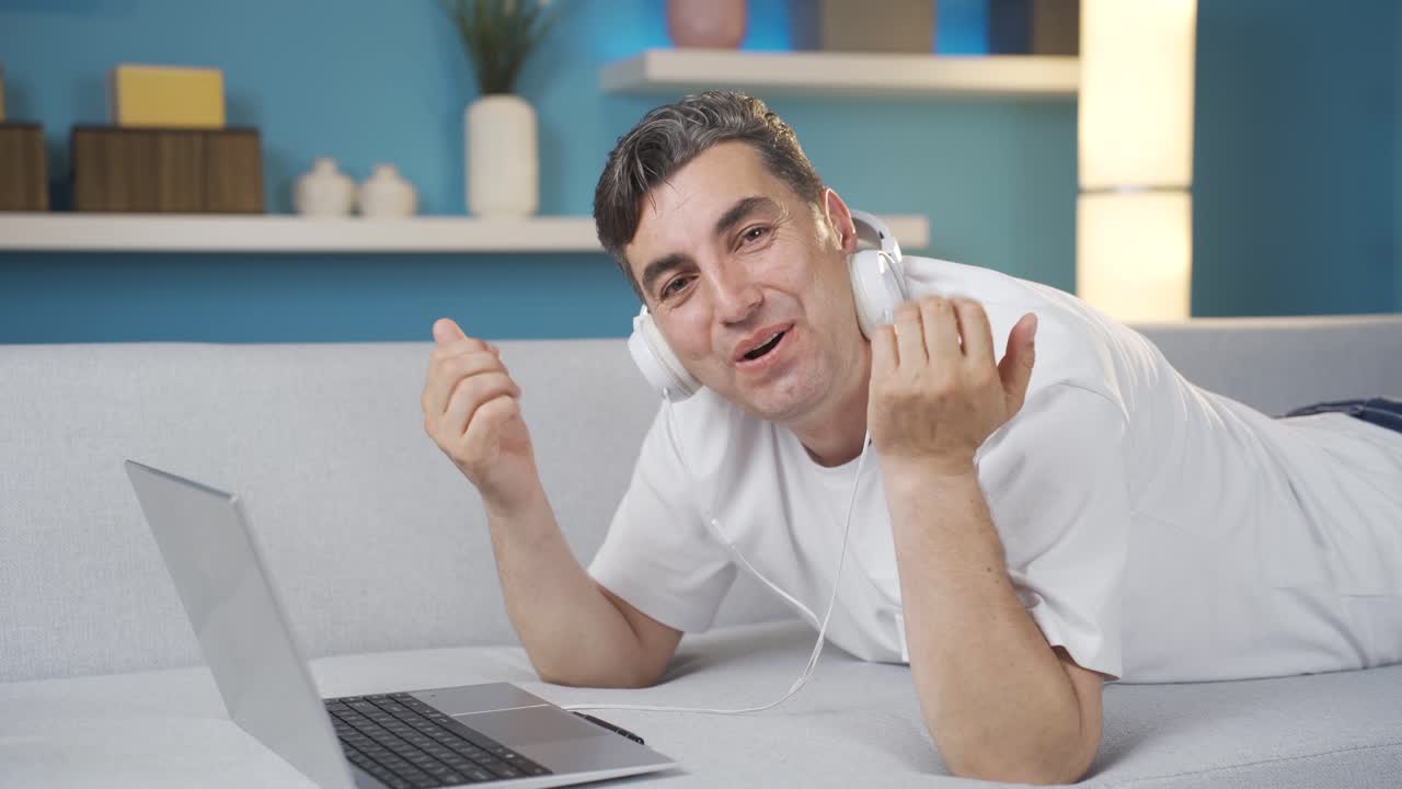 긍정적이고 만족스러운 에너지 넘치는 남자가 카메라를 쳐다보고 있습니다.