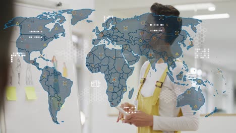 animation of world map over biracial businesswoman in office