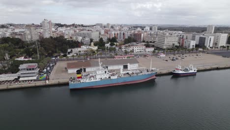 aerial tracking docked work ship in industrial port of huelva, spain