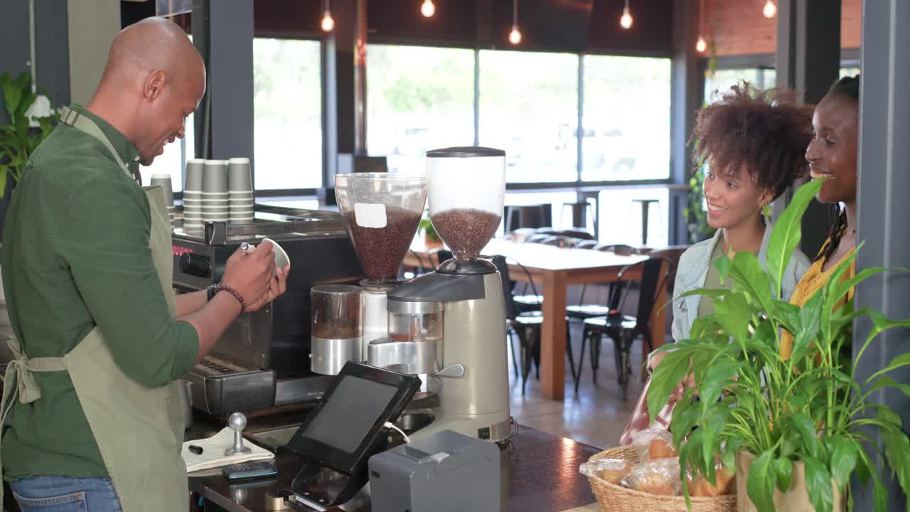 Donne afroamericane che ordinano al bancone di un bar, barista che macina il caffè e consegna la tazza, spazio per il testo