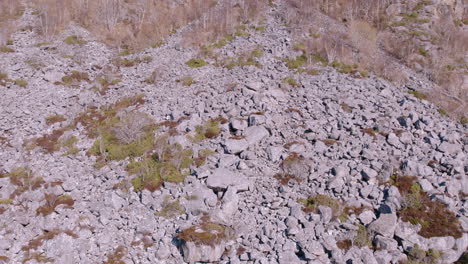 drone volando por la ladera de una montaña llena de rocas