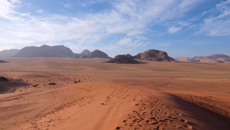 panoramic landscape view of hostile, barren red sandy desert and mountainous terrain of arabian wadi rum in jordan, middle east