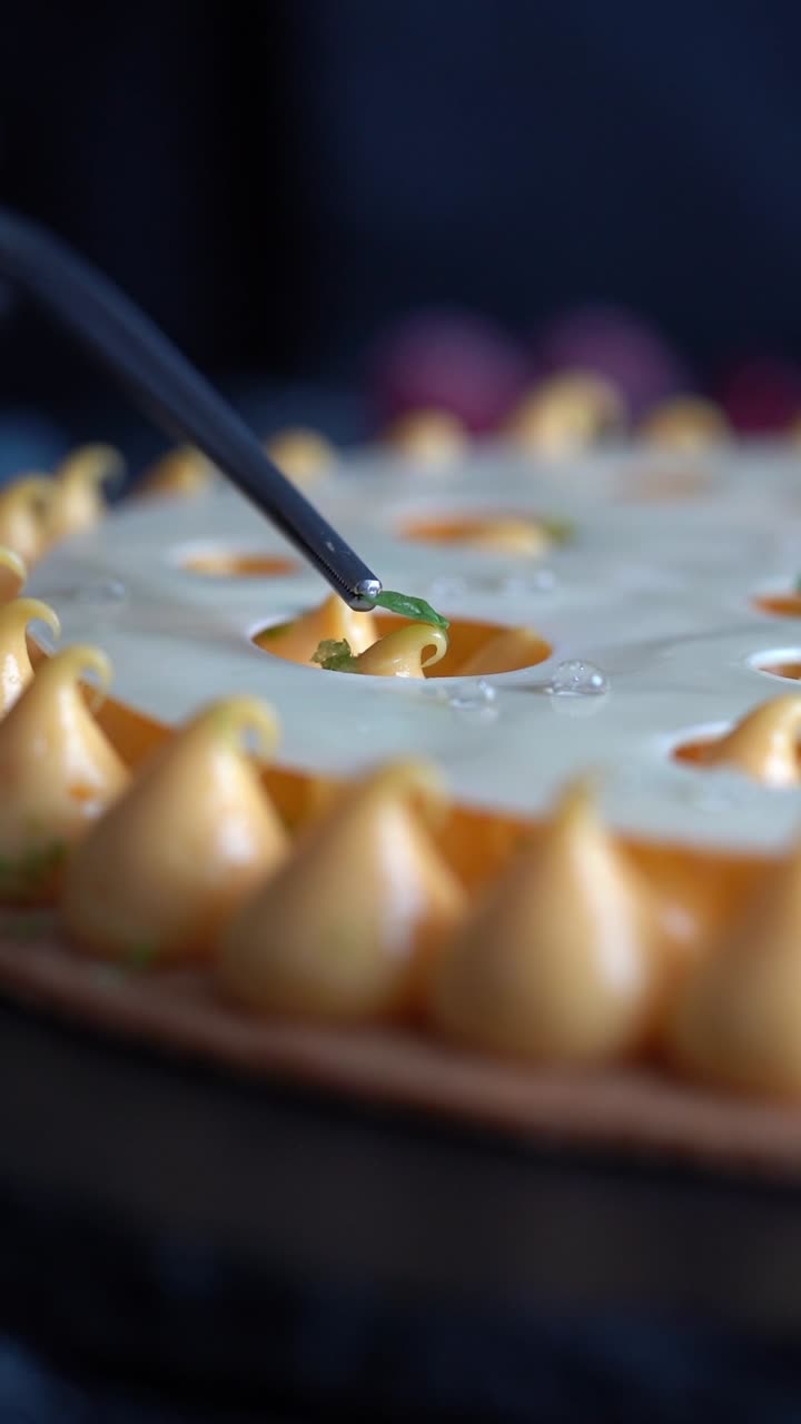 Ein Chefkoch dekorierte eine cremige Gateau mit einem Minzblatt, Nahaufnahme, Insert-Aufnahme