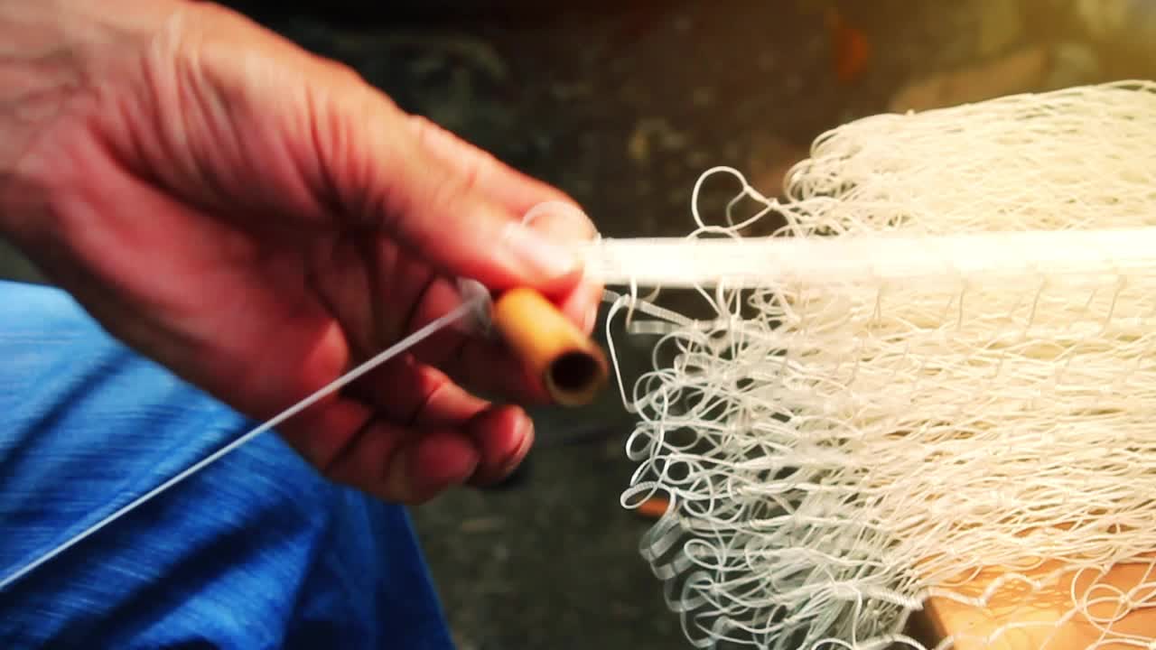 ⁇ 시 ⁇  이 물고기 그물 을 수리 하고 있다