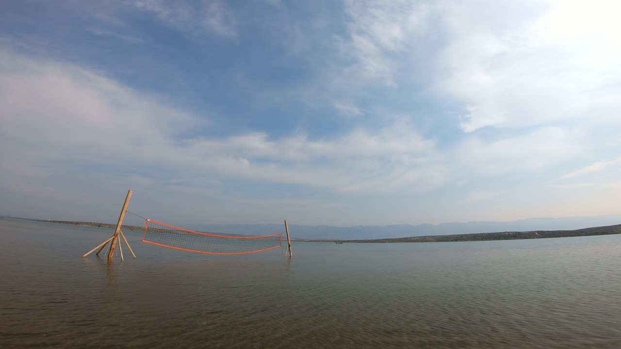 플레이어를 위한 배구 네트가 있는 모래 해변에서 이른 아침