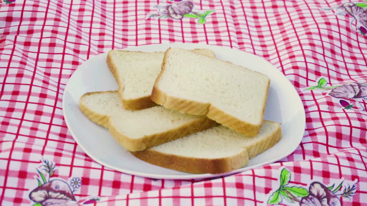 Hand leave in slow motion a slice bread in a bunch of other slice breads outside in the morning camping in the nature