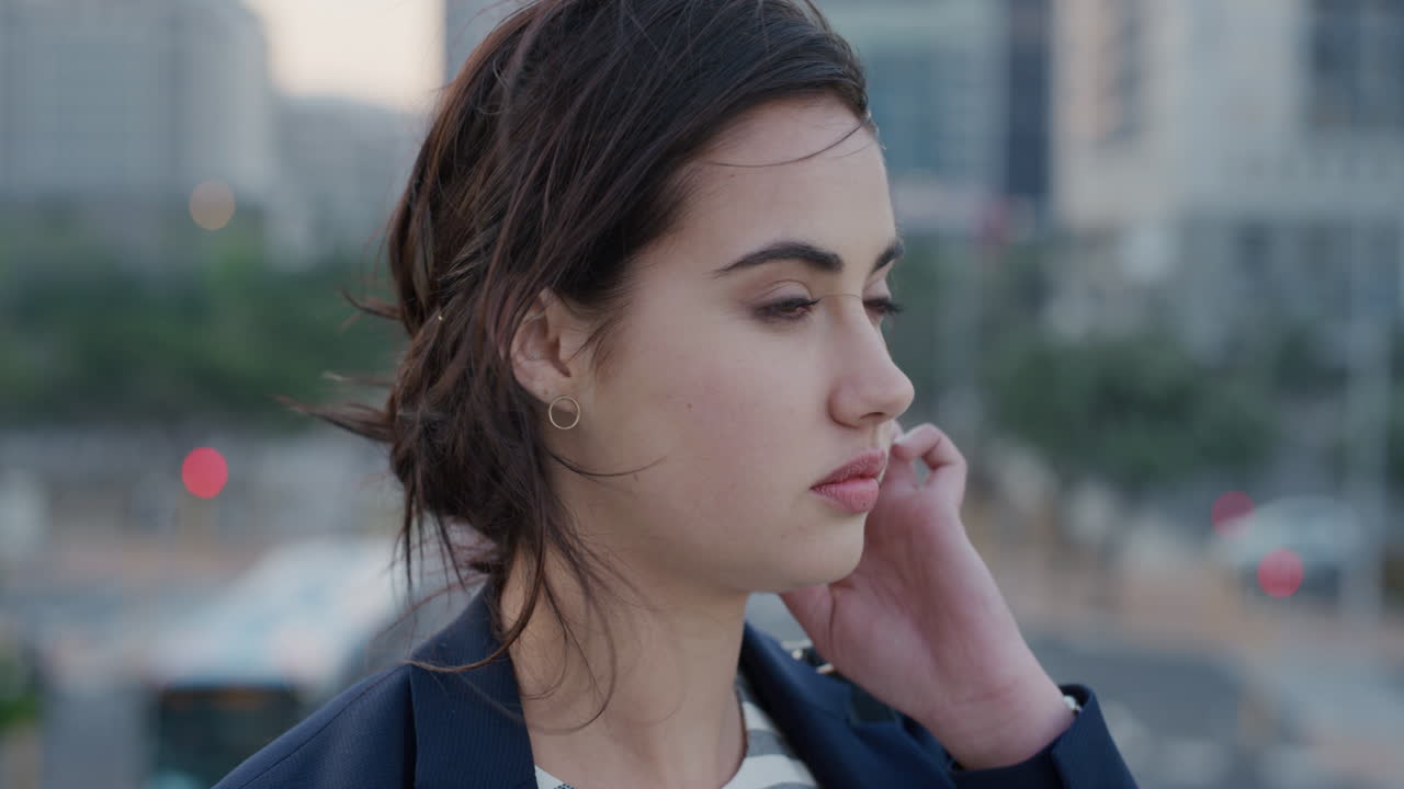 retrato joven hermosa mujer de negocios esperando en una ciudad ocupada buscando pensativa independiente mujer caucásica corriendo mano a través del cabello viento soplando cámara lenta