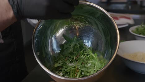 onions are added to a bowl of fresh arugula, contributing to a vibrant salad