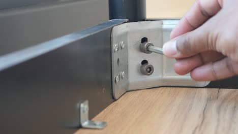 a person assembling furniture with a screwdriver