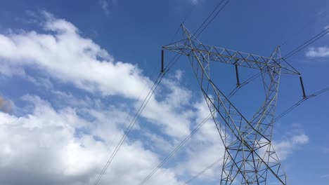 timelapse of moving clouds above the high tension electric tower in paddy fields of india