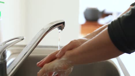 Caucasian-woman-washing-her-hands-with-soap-at-home