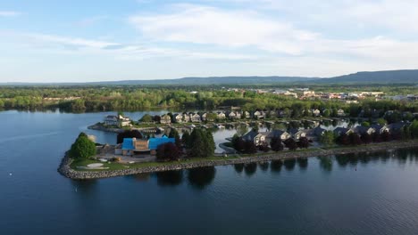 drone circling over houses built on a lake peninsula in collingwood